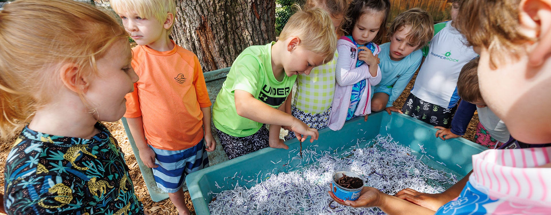 Students at the Nancy Darden Child Development Center look at worms being use to make compost. The compost will be put in the garden at the center.