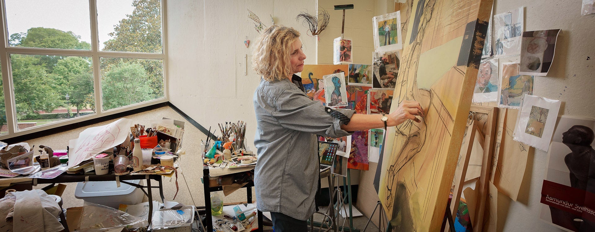 Master of Fine Arts student Loraine Scalamoni paints in Jenkins Fine Arts Building. The School of Art and Design offers graduate programs in art and art education.