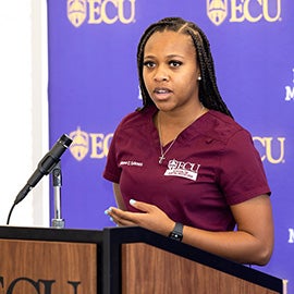 ECU Dental student gives talk at podium