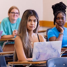 ECU student in class at desk with computer