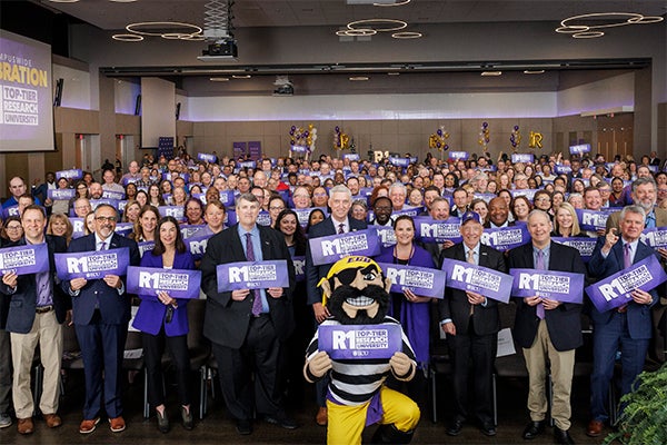 A large crowd of faculty and staff celebrate